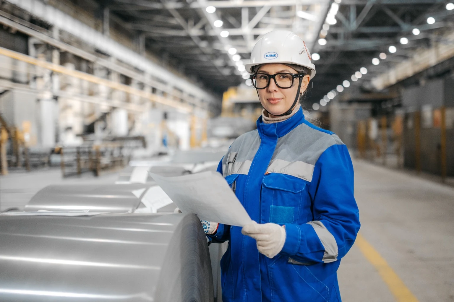 Engineer in a modern manufacturing environment with industrial machinery